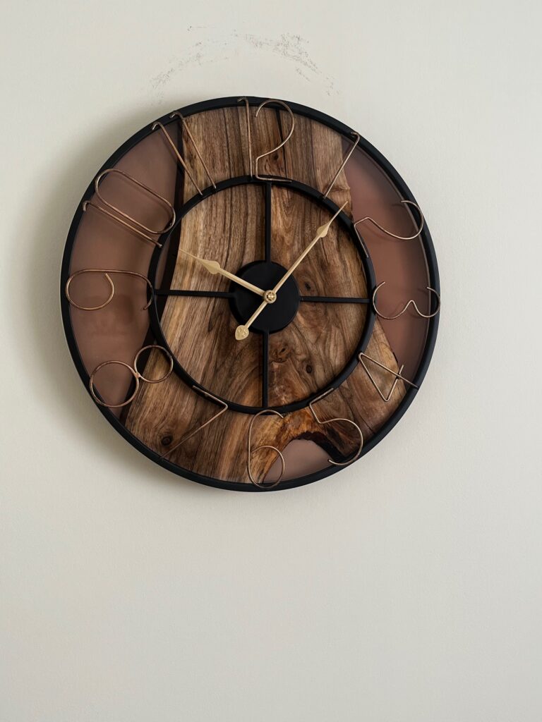 ciemny zegar z żywicy i drewna na jasnym tle